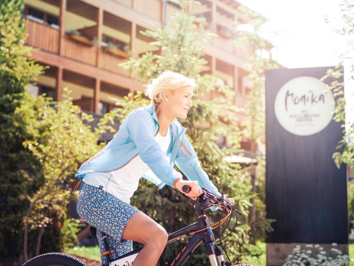 Hotel Monika Sexten Exteriör bild A woman cycling in the resort